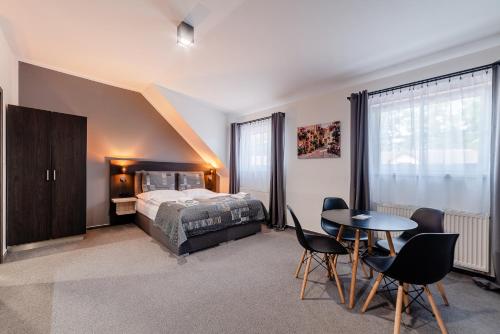 a bedroom with a bed and a table and chairs at Třeboňské Apartmány in Třeboň