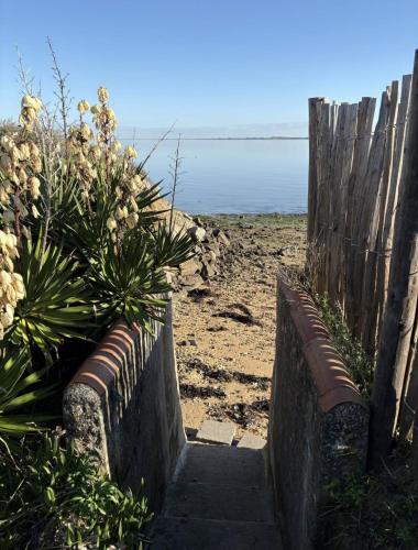 a stairway leading to a beach with a wooden fence at L'escale les pieds dans l'eau in Barbâtre