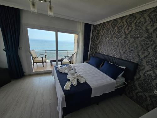 a bedroom with a bed with a view of the ocean at erşan hotel in Foça