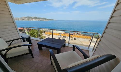 a balcony with chairs and a table and the ocean at erşan hotel in Foça