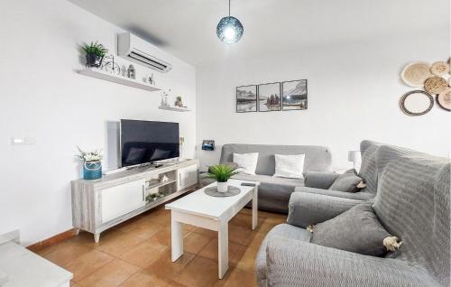 a living room with a couch and a tv at La Escapadita in Benaoján