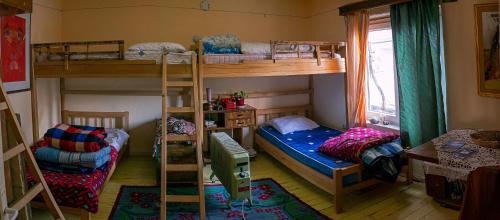 a room with two bunk beds and a window at At Home Hostel in Korçë