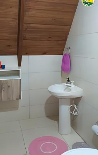 a bathroom with a sink and a toilet at Chalé Primavera Rosa com piscina in Penha