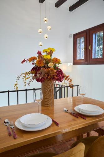 a wooden table with two plates and a vase of flowers at Villa Belora in Gera Lario