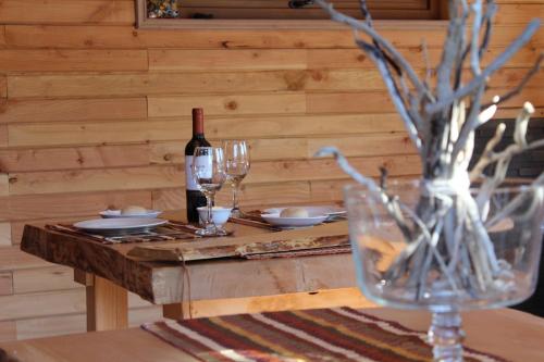 a table with a bottle of wine and glasses at Baker Domo Lodge in Cochrane