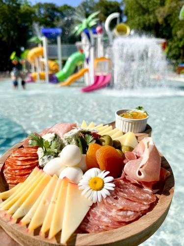 a plate of cheese and meats on a table at a water park at Rafain Palace Hotel & Convention Center in Foz do Iguaçu