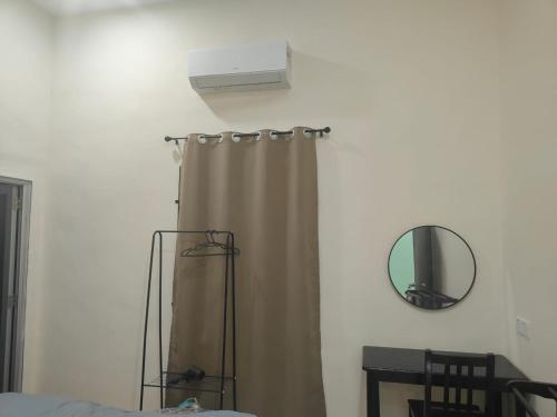 a bedroom with a shower curtain and a mirror at Seri Mersing Villa A in Mersing