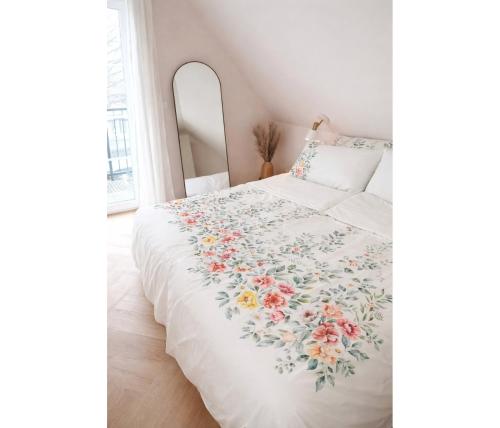 a bedroom with a bed with a floral bedspread at Top bewertete 2-Zimmer-Wohnung mit sehr gut ausgestatteter Küche, Netflix und gemütlichem Schlafzimmer in Hildesheim in Hildesheim