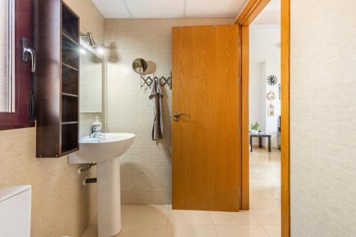 a bathroom with a sink and a wooden door at Amazing Sea View! in Isla Plana