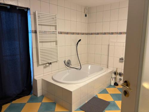 a bath tub in a bathroom with a blue shower curtain at Vilseck Stay in Vilseck