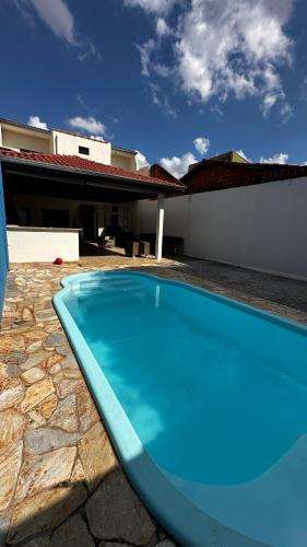 a blue swimming pool in front of a house at Espaço Quinze - Hospedagem e Lazer in Ribeirão Preto