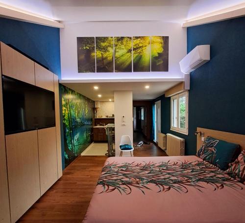 a bedroom with a large bed and a blue wall at LES CLEFS DU PARADIS avec SPA in Montferrand-le-Château