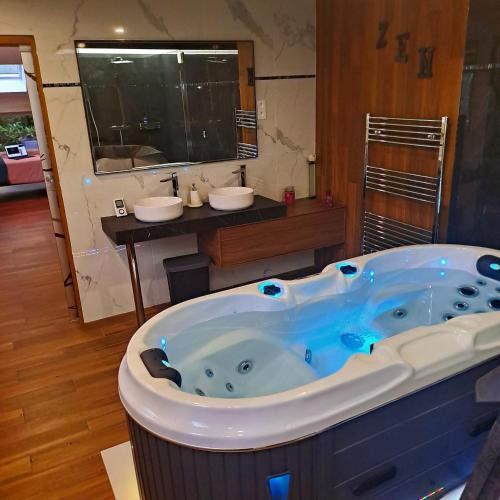 a bathroom with two sinks and a large tub at LES CLEFS DU PARADIS avec SPA in Montferrand-le-Château