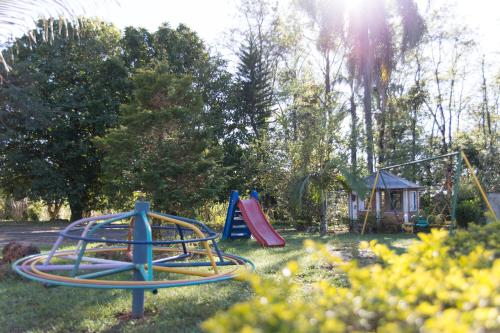 a playground with a slide and a swing set at Pousada Chácara Rama in Botucatu