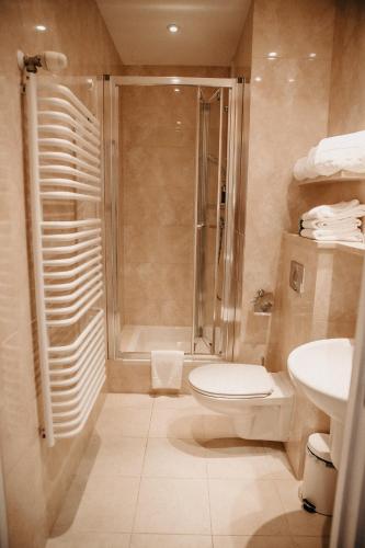 a bathroom with a shower and a toilet and a sink at Hotel Bryza Resort & Spa in Jurata