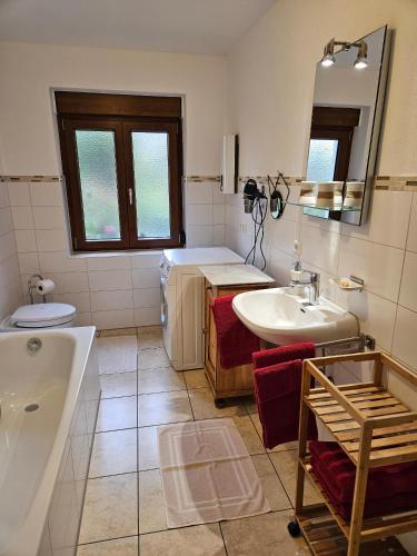 a bathroom with a tub and a sink and a mirror at Ferienwohnung Schindler in Nittenau
