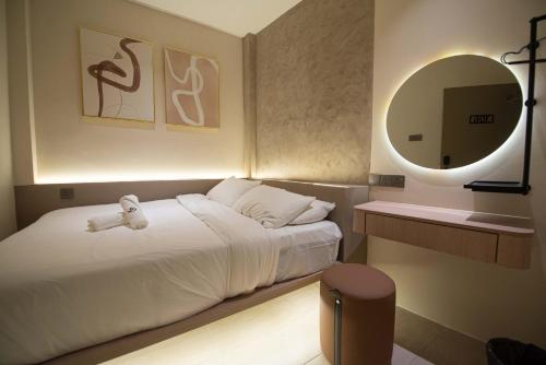 a bedroom with a white bed and a mirror at DeLuma-Lebuh Acheh in George Town
