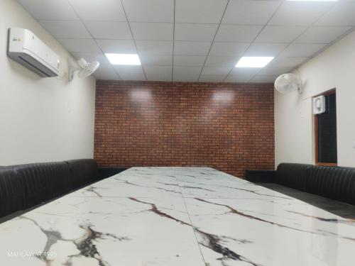 a conference room with a large marble table in front of a brick wall at Hotel Heaven Blu in Hodal