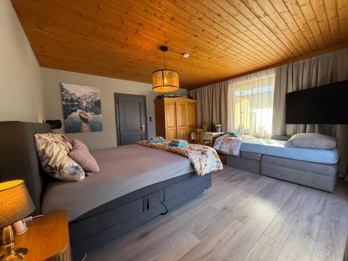 a bedroom with two beds and a television in it at Haus RuHe in Döllach