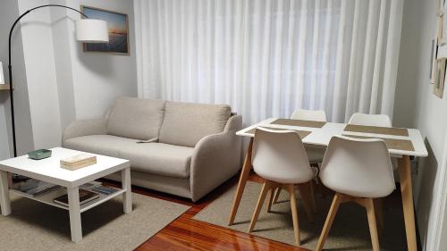 a living room with a couch and a table and chairs at Apartamento turístico CasacheloCangas en el corazón de Cangas, PLAYAS, CIES,VIGO in Cangas de Morrazo