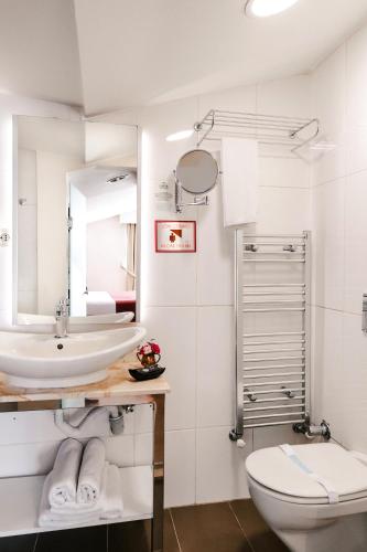 a bathroom with a sink and a toilet and a mirror at Cheya Beşiktaş Istanbul Bosphorus City Center Hotel & Suites in Istanbul