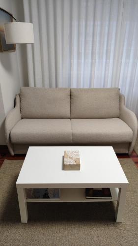 a living room with a couch and a white coffee table at Apartamento turístico CasacheloCangas en el corazón de Cangas, PLAYAS, CIES,VIGO in Cangas de Morrazo