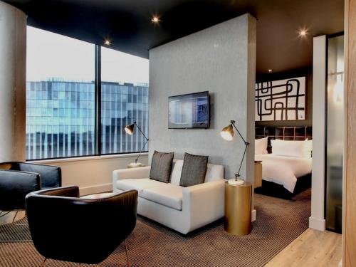 a hotel room with a couch and a bed at Century City Hotel Urban Square in Cape Town