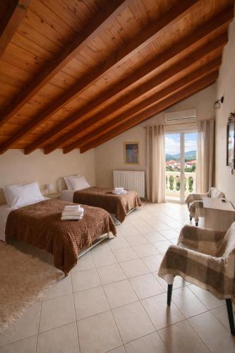 a bedroom with two beds and a large window at Konitsa Horizon Villa in Konitsa