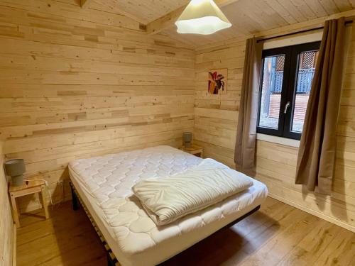 a bedroom with a bed in a wooden room at Chalet neuf proche des stations de ski in Saint-Pons