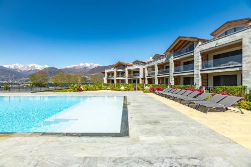 a swimming pool at a resort with mountains in the background at Lago Dorato Luxury Apartments - Lake Como View in Colico
