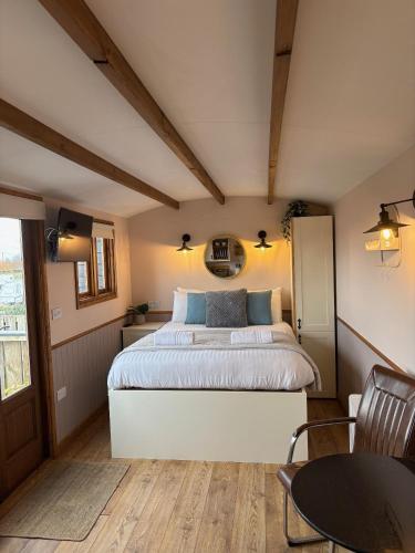 a bedroom with a large bed and a table at Hafod Shepherd Hut in Aberystwyth