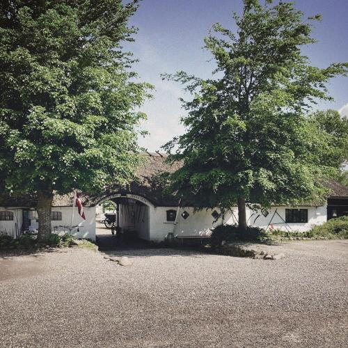 a white house with two trees in front of it at Svostrup Kro in Silkeborg
