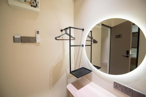a bathroom with a round mirror and stairs at DeLuma-Lebuh Acheh in George Town