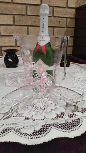 a wine bottle in a glass holder on a table at Villa Majestic for Exclusive Accommodation in Port Alfred