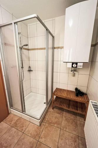 a shower with a glass door in a bathroom at Ferienhaus Seepark 104 in Hoddersdeich