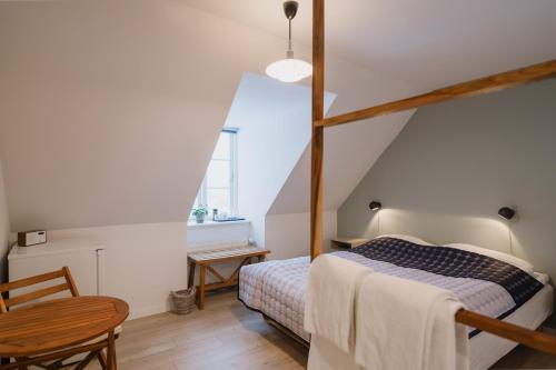 ein kleines Schlafzimmer mit einem Bett und einem Tisch in der Unterkunft Aroma Guesthouse in Ærøskøbing