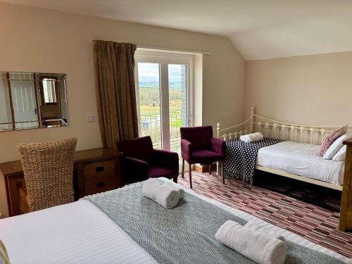 a hotel room with two beds and a window at Brynhyfryd in Aberystwyth