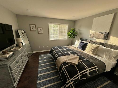 a bedroom with a bed and a dresser and a television at Cozy Modern Villa in New Castle