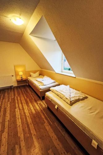 two beds in a room with a roof at Ferienhaus Seepark 104 in Hoddersdeich