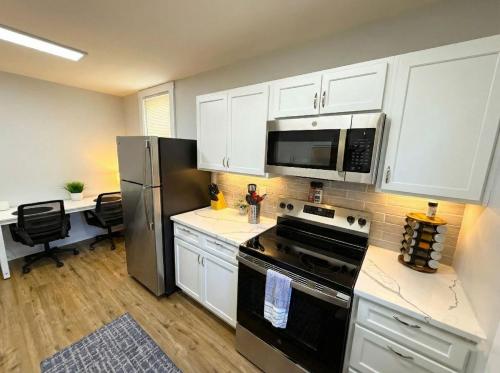 a kitchen with white cabinets and a stove and refrigerator at Cozy unit King bed & laundry in Wilmington
