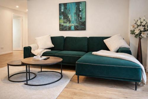 a living room with a green couch and a table at Spacious apartment in Leigh woods in Bristol