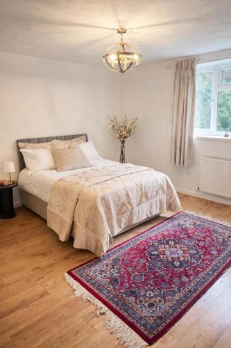 a bedroom with a bed with a rug and a chandelier at Spacious apartment in Leigh woods in Bristol