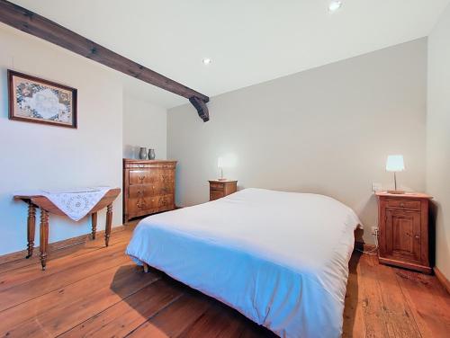 a bedroom with a white bed and a wooden floor at Les Perles du Ried - Gîte 6 - proche Europapark Strasbourg Colmar in Boofzheim