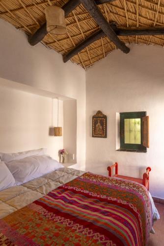 a bedroom with a bed with a rug on it at Los Arcabuceros Casa Hotel Boutique in Tilcara