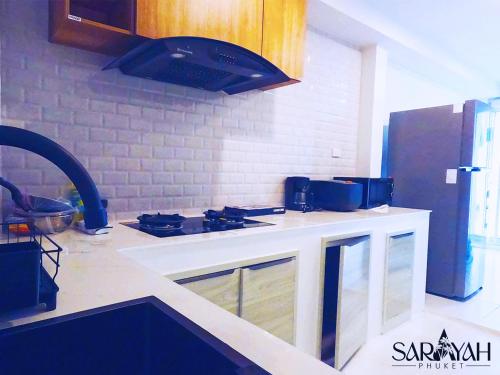 a kitchen with a stove and a counter top at Sarayah Phuket Pool Villa in Phuket