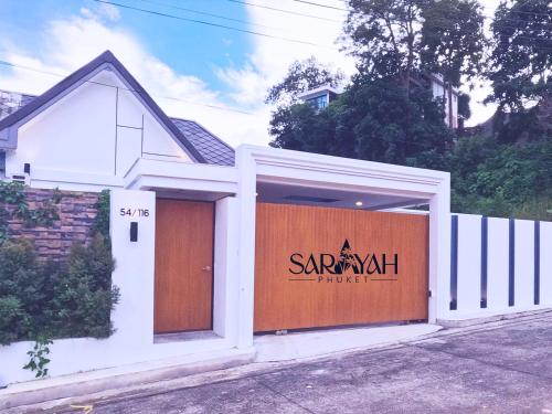 a saranak house with a garage with a sign on it at Sarayah Phuket Pool Villa in Phuket