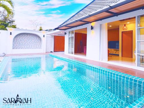 a swimming pool in front of a house at Sarayah Phuket Pool Villa in Phuket