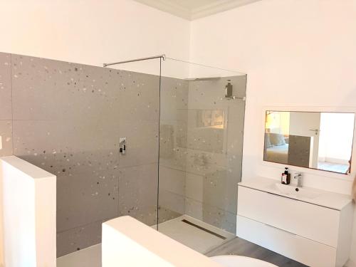 a bathroom with a shower and a toilet and a sink at Beachouse@Stilbaai in Stilbaai