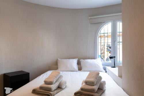 a bedroom with a bed with towels on it at Casa SD in Casas de Torrat