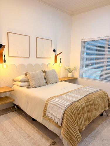 a bedroom with a large bed and a window at Beachouse@Stilbaai in Stilbaai